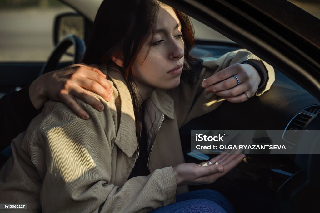 young people's problems a young girl, a passenger in a car, has a handful of psychotropic and painkillers in her hand, she has mental problems, fears and phobias, pains. 18-19 Years Stock Photo