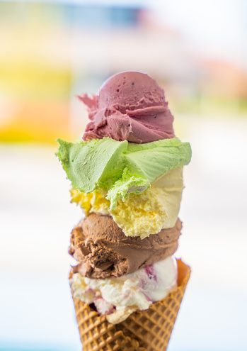 Stack of colorful ice cream scoops in waffle cone