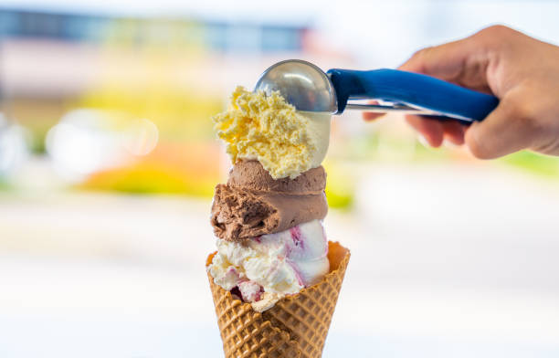 hombre sirviendo bolas de helado de diferentes colores en cono - scoop ice cream frozen cold fotografías e imágenes de stock