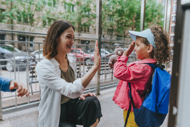 istock Happy smiling woman teacher greeting elementary school students 1413062209