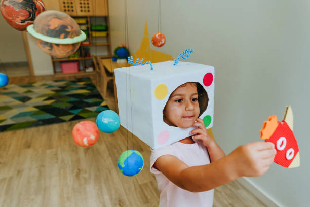 istock Little girl playing with paper spaceship learning Solar system planets 1413062496