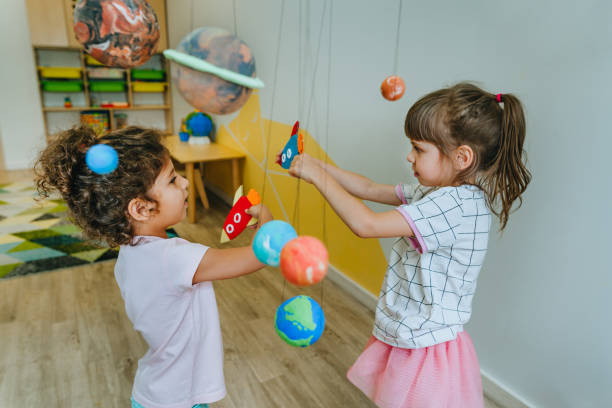 istock Little girl playing with paper spaceship learning Solar system planets 1413062497