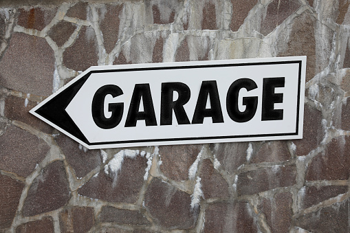 arrow with big garage word indicating the direction for parking cars
