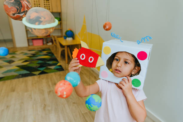 istock Little girl playing with paper spaceship learning Solar system planets 1413062654