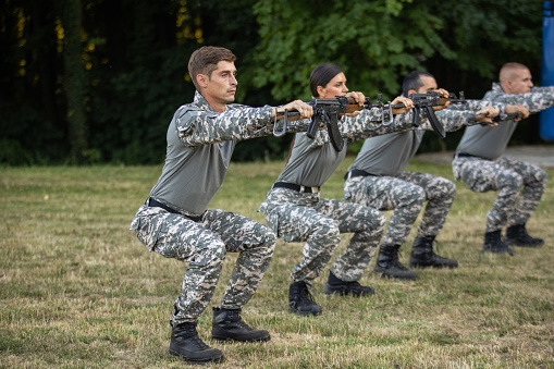 Caucasian female and male military team, having an outdoor ground military training
