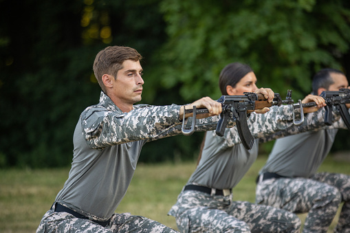 Soldiers crawling under the net during obstacle course in boot camp