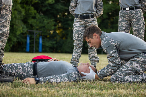 Military team having an first aid training course