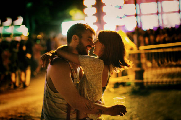 Love at a music festival. Young couple enjoying at music festival. kissing on the mouth stock pictures, royalty-free photos & images