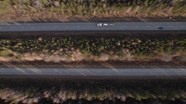 carros de trânsito em estrada de várias pistas entre florestas profundas - multiple lane highway highway car field - fotografias e filmes do acervo