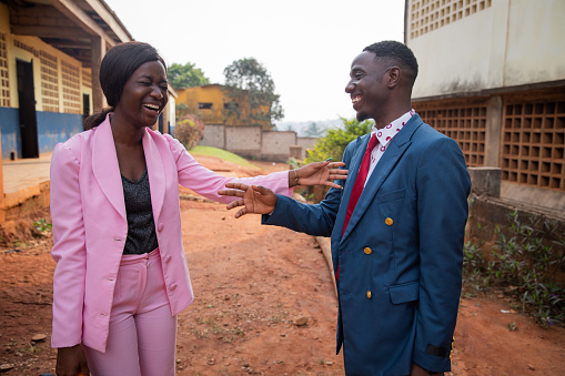Two male and female colleagues laugh during a conversation, african people at work