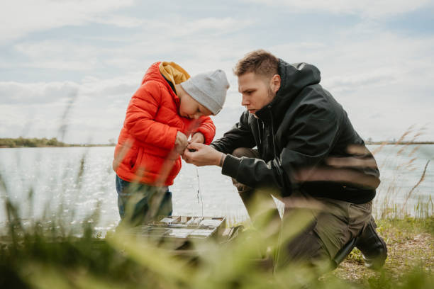 istock Father and son preparing fishing rod with bait 1413067498