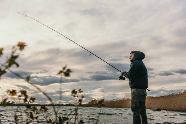 istock Young man fishing in river 1413067760
