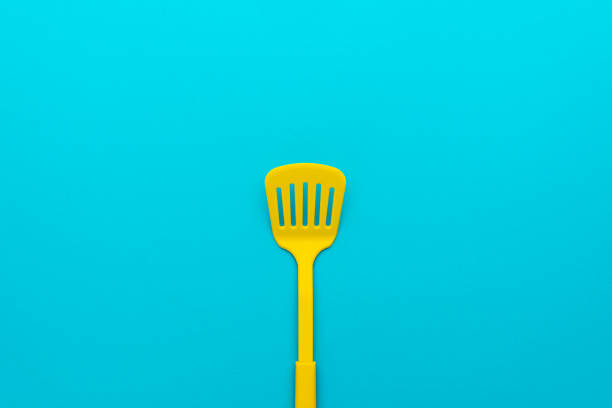 istock Top view of yellow slotted spatula on turquoise blue background with copy space 1413068211