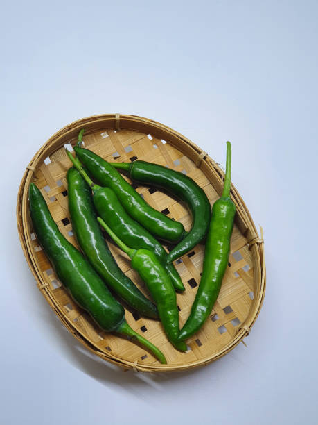 istock Green chillies on wooden plate,isolated on white background. 1413070631