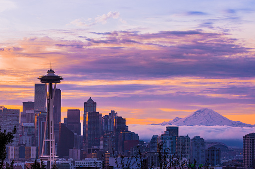 The sun rises over Seattle, with a view of the Space Needle and Mount Rainier