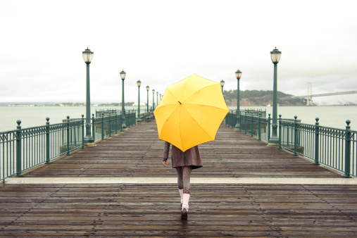 A girl with an umbrella on a San Francisco pier