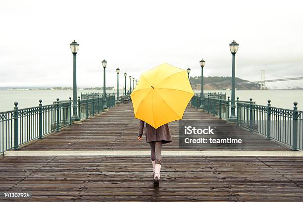 A Girl With An Umbrella On A San Francisco Pier Stock Photo - Download Image Now - Umbrella, Yellow, Rain