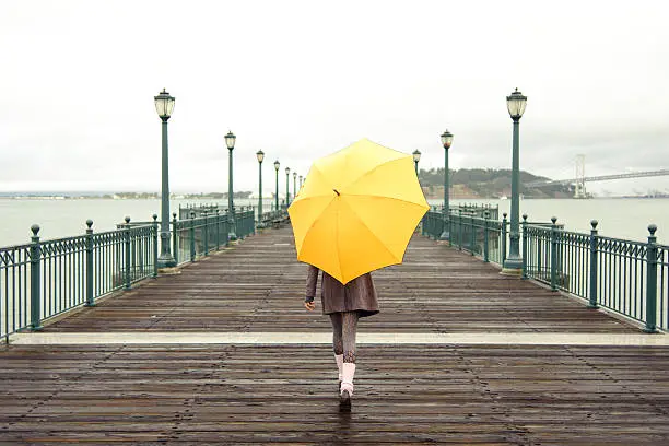 Photo of A girl with an umbrella on a San Francisco pier