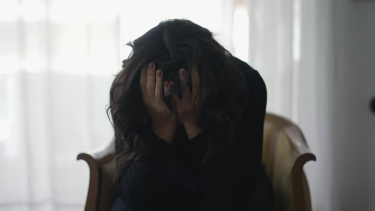 Woman covering face in shame suffering from emotional pain