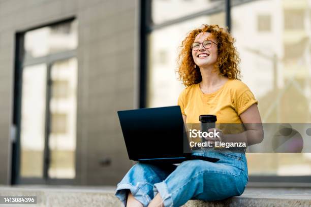 Young Redhead Woman Working On Laptop In The City Stock Photo - Download Image Now - Yellow, Laptop, Women