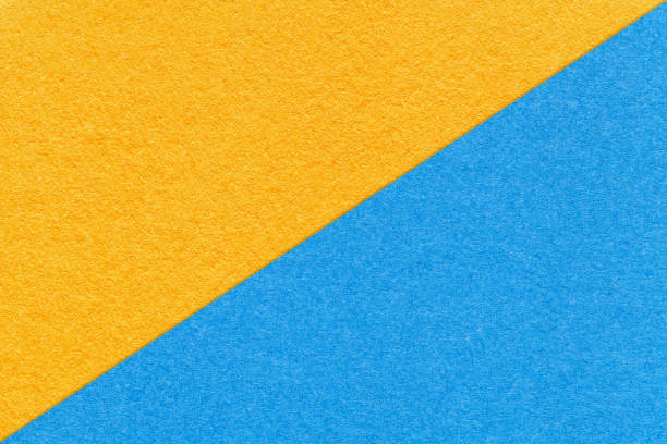 istock Texture of craft yellow and light blue paper background, half two colors, macro. Structure of kraft cardboard. 1413085773