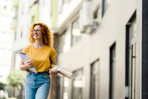 istock Young redhead female architect walking on the street 1413086303