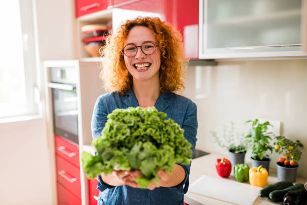 istock Smiling ginger woman in the red kitchen 1413087317