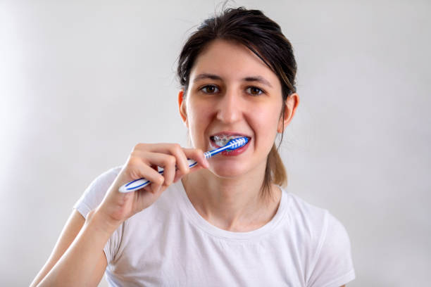 istock Young woman is brushing her teeth in a bathroom 1413088123