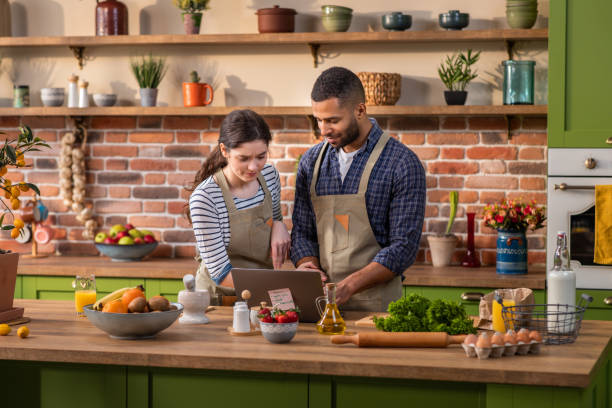 istock Large modern kitchen island excited with a large smile couple multiracial cut some fresh fruits to prepare the healthy breakfast together they discussing and feeling happy 1413088813