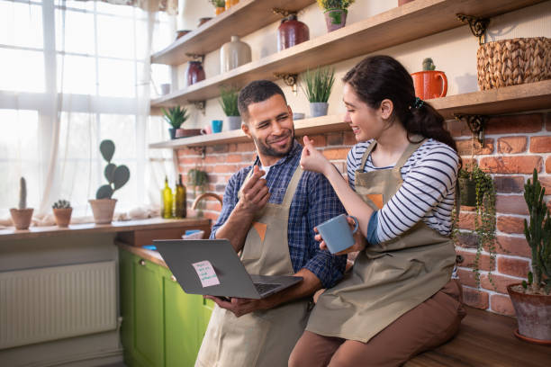 istock In the kitchen happy woman while take a sit over the kitchen table she using her laptop to type the shopping list she are excited and looking awesome 1413088954