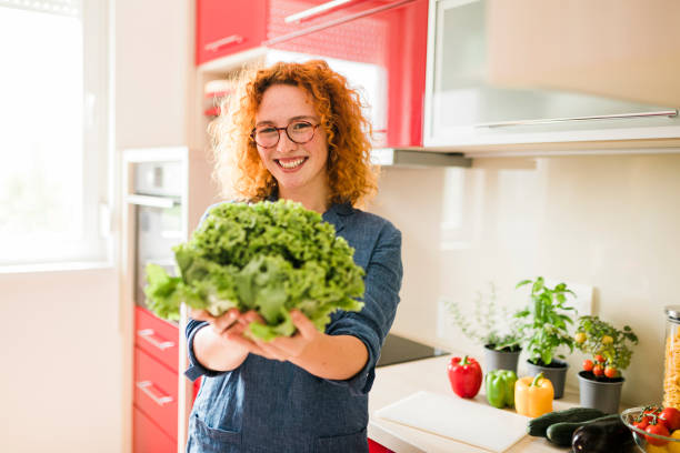 istock Smiling ginger woman in the red kitchen 1413089802