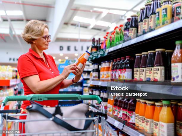 Woman Shopping In The Supermarket Stock Photo - Download Image Now - Juice - Drink, Refrigerator, 45-49 Years