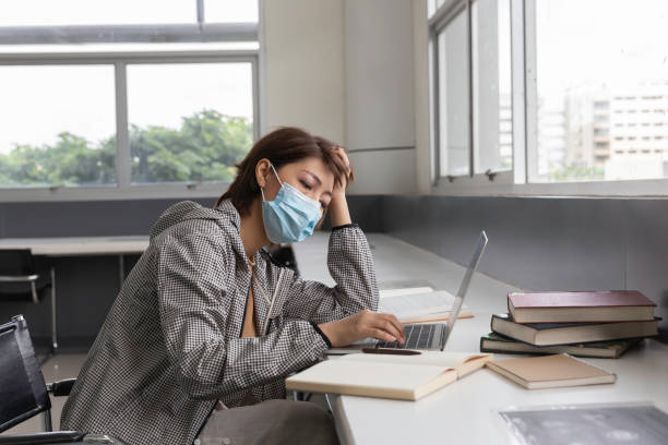 istock Beautiful woman wearing a face mask read book in library. 1413091109