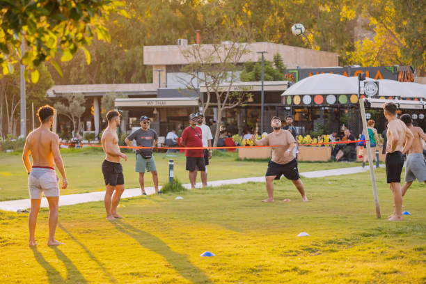 gente divirtiéndose mientras juegan pateando voleibol de pies en una hierba. deporte sepaktakraw malayo - sepak takraw fotografías e imágenes de stock