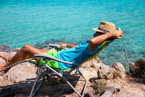istock Portrait of a handsome man lying on a deckchair and resting. 1413092178