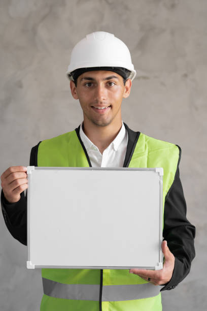 istock Portrait of arabic engineer with blank space, male architect holding whiteboard for text on gray background, building and renovation 1413092303