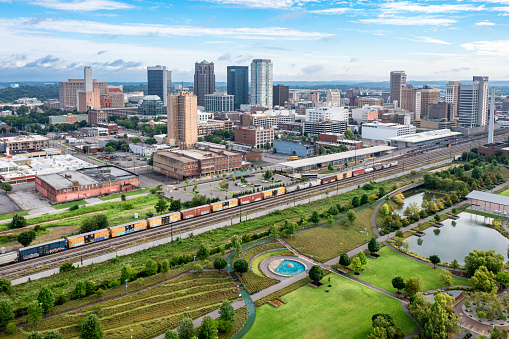 Aerial drone view of Birmingham, Alabama skyline with park and train in the foreground.