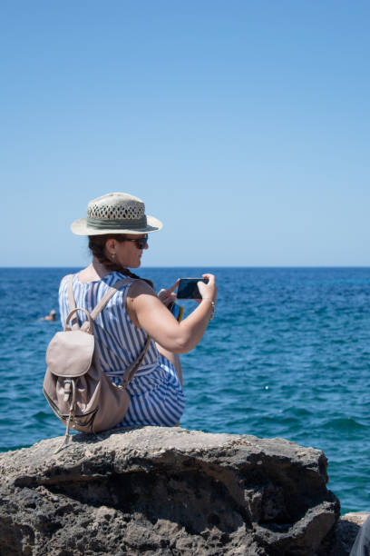 istock Woman in a cove taking photos 1413095486