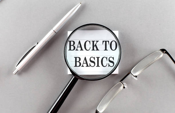 istock Word BACK TO BASICS on sticky through magnifier on grey background 1413096179