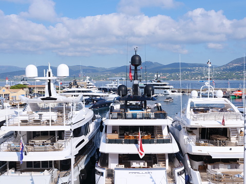 Closeup side view of white luxury motor yacht in marina, full frame horizontal composition