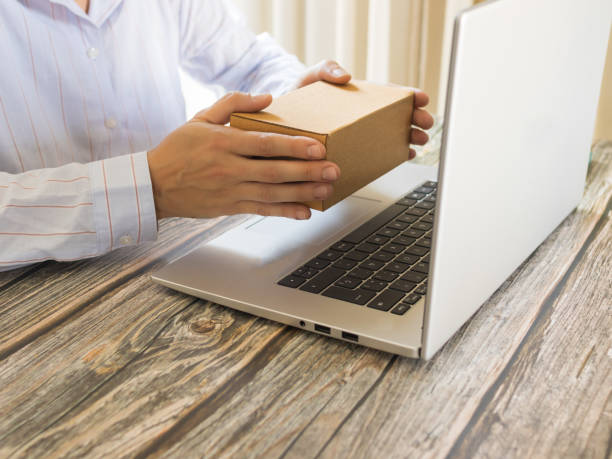 istock Person teleworking with online order box in front of the computer 1413108253