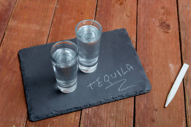 테킬라라는 단어가 적힌 돌판에 데킬라 2장 - tequila reposado 뉴스 사진 이미지