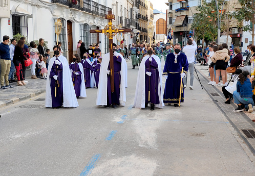 Coin Spain - April 2022. Tourist walking in the Catholic procesion of holy week in a sunny day.