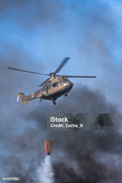 Military Helicopter Assists Firefighters In Extinguishing Forest Fire Stock Photo - Download Image Now