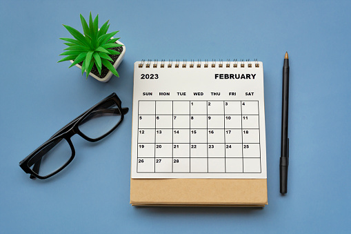 Calendario de escritorio de febrero de 2023 sobre fondo azul. Directamente arriba. photo