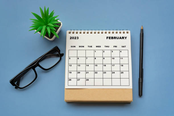 February 2023 desk calendar on blue background. Directly above. stock photo