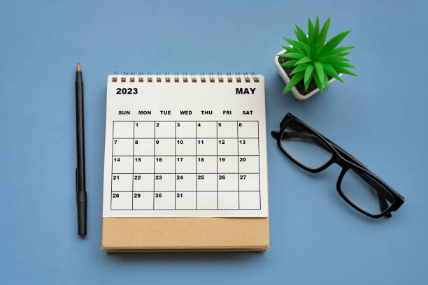 May 2023 desk calendar on blue background. Directly above. stock photo