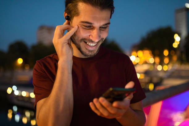 Man having a video call using smartphone in city at night stock photo