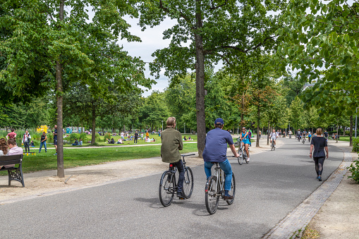 Amsterdam, Netherlands, July 10, 2022; People cycle and walk through the Vondelpark in Amsterdam.