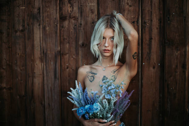 istock Blonde woman posing with flowers in modern way. 1413126879